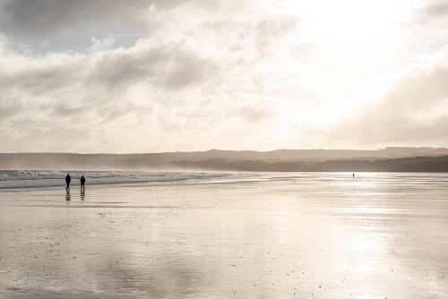 two people standing on a beach near the ocean at The Pigsty in Slingsby