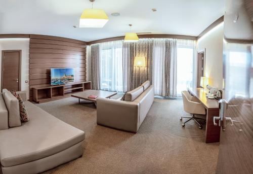a large living room with a couch and a desk at Arfa Park-Hotel in Adler