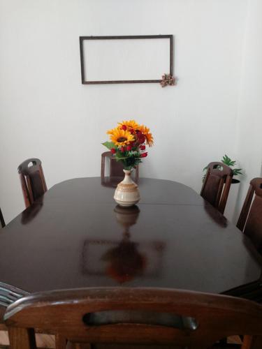 a table with a vase with orange flowers on it at Sunshine house in Pančevo