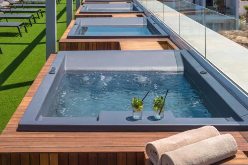 een zwembad met twee drankjes erin op een gebouw bij Sensus Experience by Lavris in Gouves