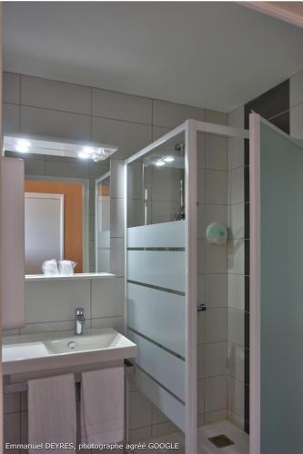 a bathroom with a sink and a shower and a mirror at Queen Serenity Hotel in Redon