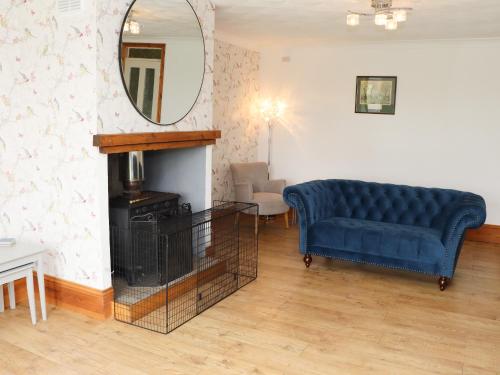 a living room with a blue couch and a mirror at 4 Roman Bank in Mablethorpe