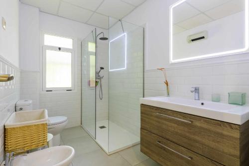 een badkamer met een toilet, een wastafel en een douche bij Casa San Rafael amplio chalet con gran jardín in Navajas