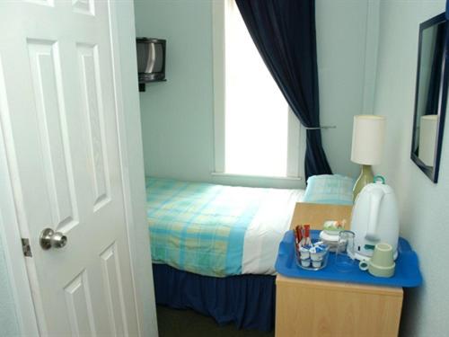 a bedroom with a bed and a table with a blue counter at Kentmere Guest House in Folkestone