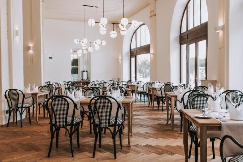 a dining room with tables and chairs and windows at Hotel Miramare in Crikvenica