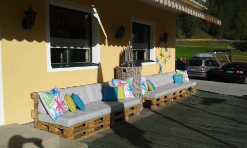 two couches sitting outside of a house at Alpin Appart Reiterhof in Niederthai