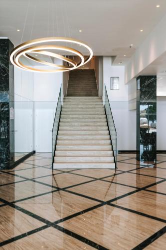 a staircase in a building with a chandelier at Hotel Miramare in Crikvenica