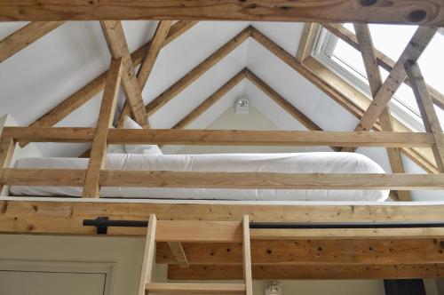 a loft bed in a room with a window at Van Heeckeren Apartments & Suites Buren in Buren