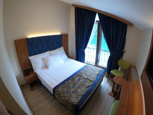 - une chambre avec un lit et une grande fenêtre dans l'établissement Şavşat Karagöl Hotel, à Savsat