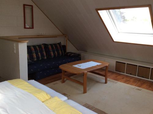 a attic room with a couch and a table at Ferienwohnung A&K in Bottrop