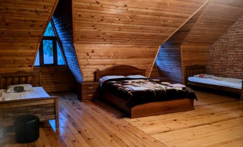 a bedroom with a bed in a wooden cabin at Hotel Texel in Borjomi