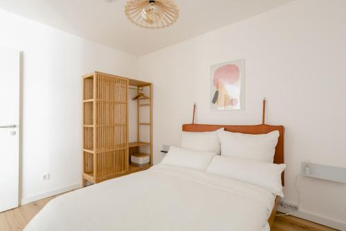 um quarto com uma cama branca e um lustre em Sweet Suite - Zentrale Wohnung nähe Augarten em Viena