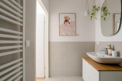 uma casa de banho com um lavatório e um espelho em Sweet Suite - Zentrale Wohnung nähe Augarten em Viena