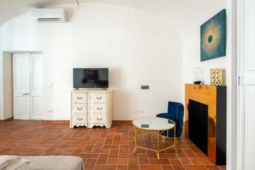 - un salon avec une télévision, une table et un meuble de télévision dans l'établissement Navona 7 Suite, à Rome