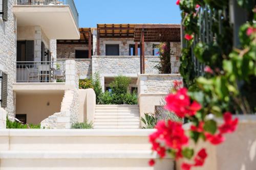 vista su un edificio con scale e fiori rossi di Margo Beach Hotel a Gythio