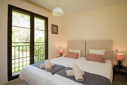 a bedroom with a large white bed with two pillows at Los Arqueros Las Jacarandas in Benahavís