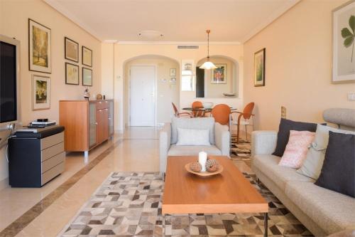 a living room with a couch and a table at Los Arqueros Las Jacarandas in Benahavís