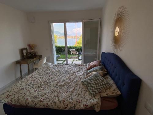 a bedroom with a bed with a blue head board at Amadeus in Baveno