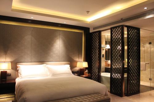 a bedroom with a large bed and a bathroom at Primus Hotel Qipan Moutain Shenyang in Shenyang