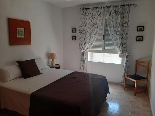 un dormitorio con una cama y una ventana en Primavera Sunshine, en Albir