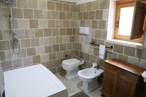 La salle de bains est pourvue de toilettes, d'un lavabo et d'une baignoire. dans l'établissement Trullo Montetrecarlini, à Alberobello