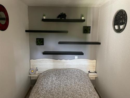 - une chambre avec un lit et des étagères sur le mur dans l'établissement Village vacances Ardèche Odalys climatisé, à Salavas