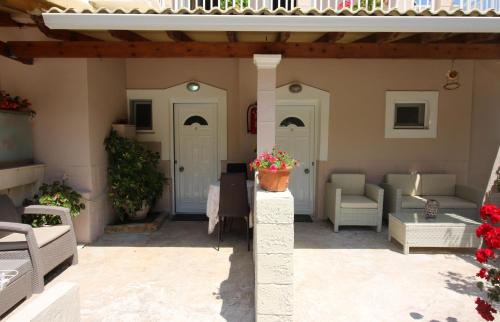 a patio with couches and a flower pot on a pole at Santa Barbara Lakis Apartments in Perivolion