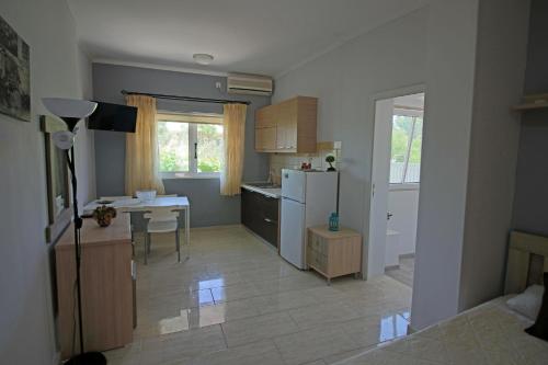 a small kitchen with a table and a refrigerator at Santa Barbara Lakis Apartments in Perivolion