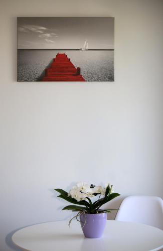 a white table with a vase with a plant on it at Santa Barbara Lakis Apartments in Perivolion