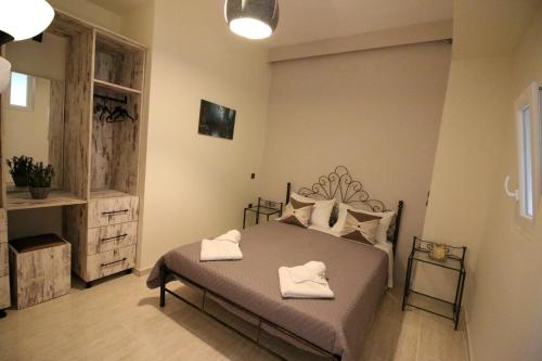 a bedroom with a bed with two towels on it at Santa Barbara Lakis Apartments in Perivolion