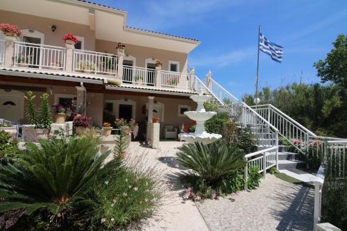 a house with a flag in front of it at Santa Barbara Lakis Apartments in Perivolion