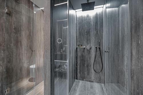 a bathroom with a shower with a glass door at Hellenic Vibes Smart Hotel in Athens