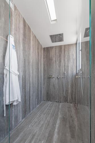 a bathroom with a shower and a glass door at Hellenic Vibes Smart Hotel in Athens