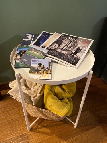 a white table with a laptop and magazines on it at Pinzolo Wellness Apartment in Pinzolo