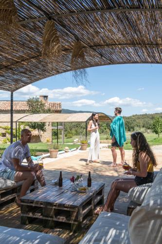 a group of people sitting around a table on a patio at ECOTurisme Can Buch HOTEL in Sant Aniol de Finestras