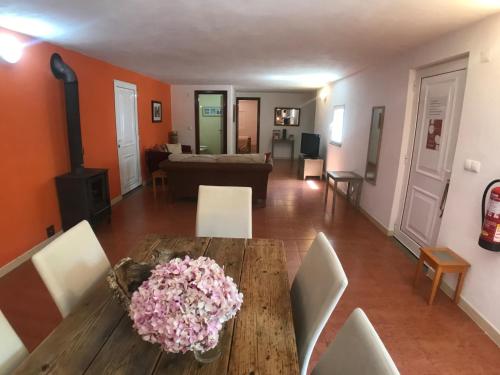 een eetkamer met een tafel en stoelen en een woonkamer bij Quinta da Barroquinha in Vale de Prazeres