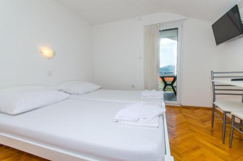 una camera con letto bianco e balcone di ADRIA a Trogir