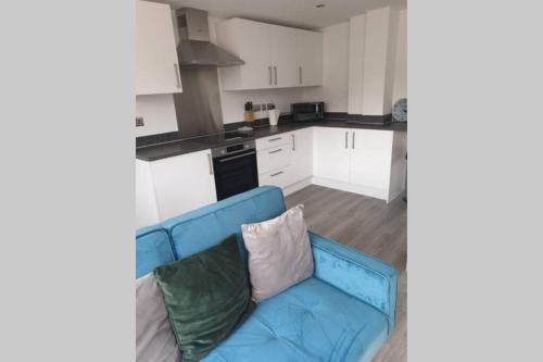 a living room with a blue couch in a kitchen at 2 bedroom, 2 bathroom, New Apartment Watford Town Centre in Watford
