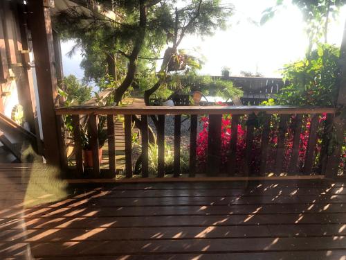 a wooden railing on a porch with a tree at Home Box in Renai