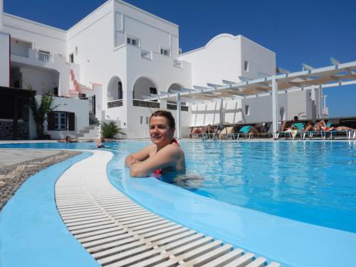a woman laying in the swimming pool at a hotel at New Haroula in Fira