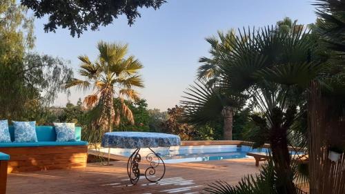 un patio con panchina e tavolo accanto alla piscina di Il Casale Del Sogno ad Ardea