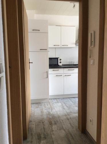uma cozinha com armários brancos e um forno com placa de fogão em Ferienwohnung A&K em Bottrop