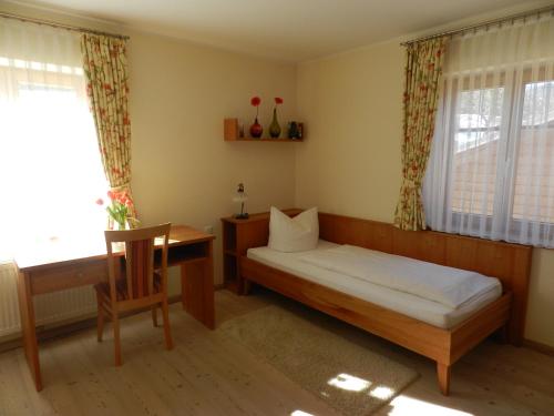 a bedroom with a bed and a desk and a window at Landhaus am Bach in Übelbach