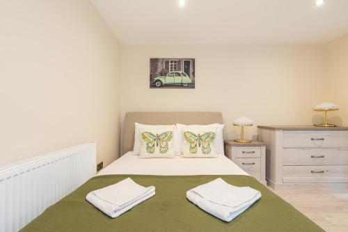 a bedroom with a bed with two towels on it at Cozy 1 Bedroom Flat Paddington in London