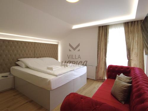 a bedroom with a large bed and a red couch at Villa Marica Šipovo in Šipovo