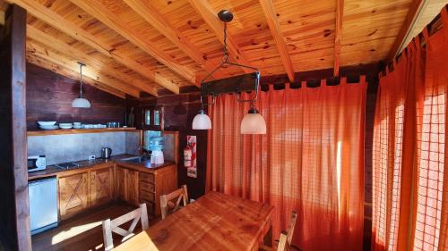 a kitchen with a wooden table and a dining room at Estancia Laguna Vitel in Chascomús