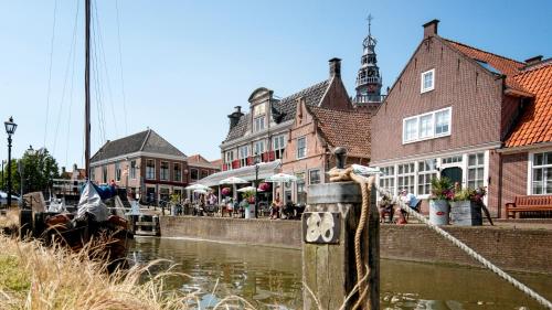 a group of buildings next to a canal with a boat at Harbour Suites Boutique Hotel in Monnickendam