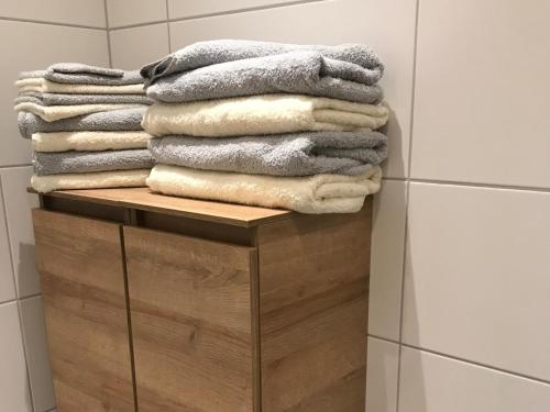 a stack of towels on a wooden shelf in a bathroom at Ferienwohnung Gassner in Piding