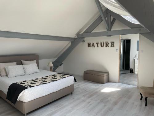 a bedroom with a bed and a sign that reads nature at Chambre d'Hotes La Chaiserie in Romeries
