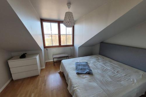 a bedroom with a bed and a dresser and a window at Golfapartment in Pickala in Siuntio